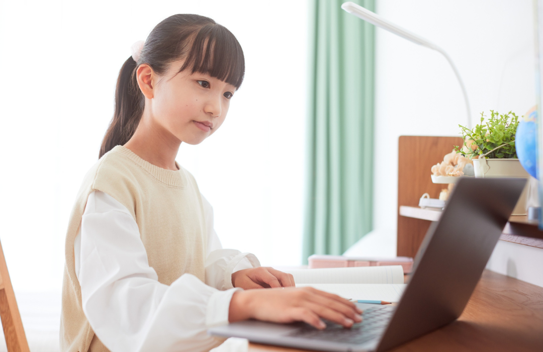 Adolescente em frente a um computador feliz.