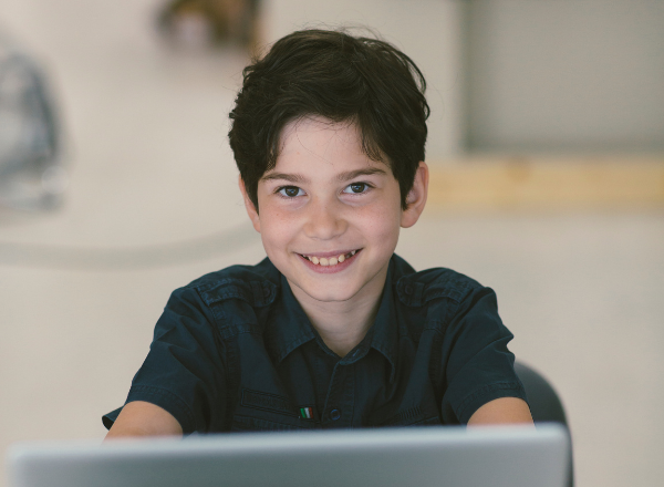 Jovem sorridente em frente a um computador