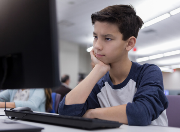 Jovem confuso ao usar um computador